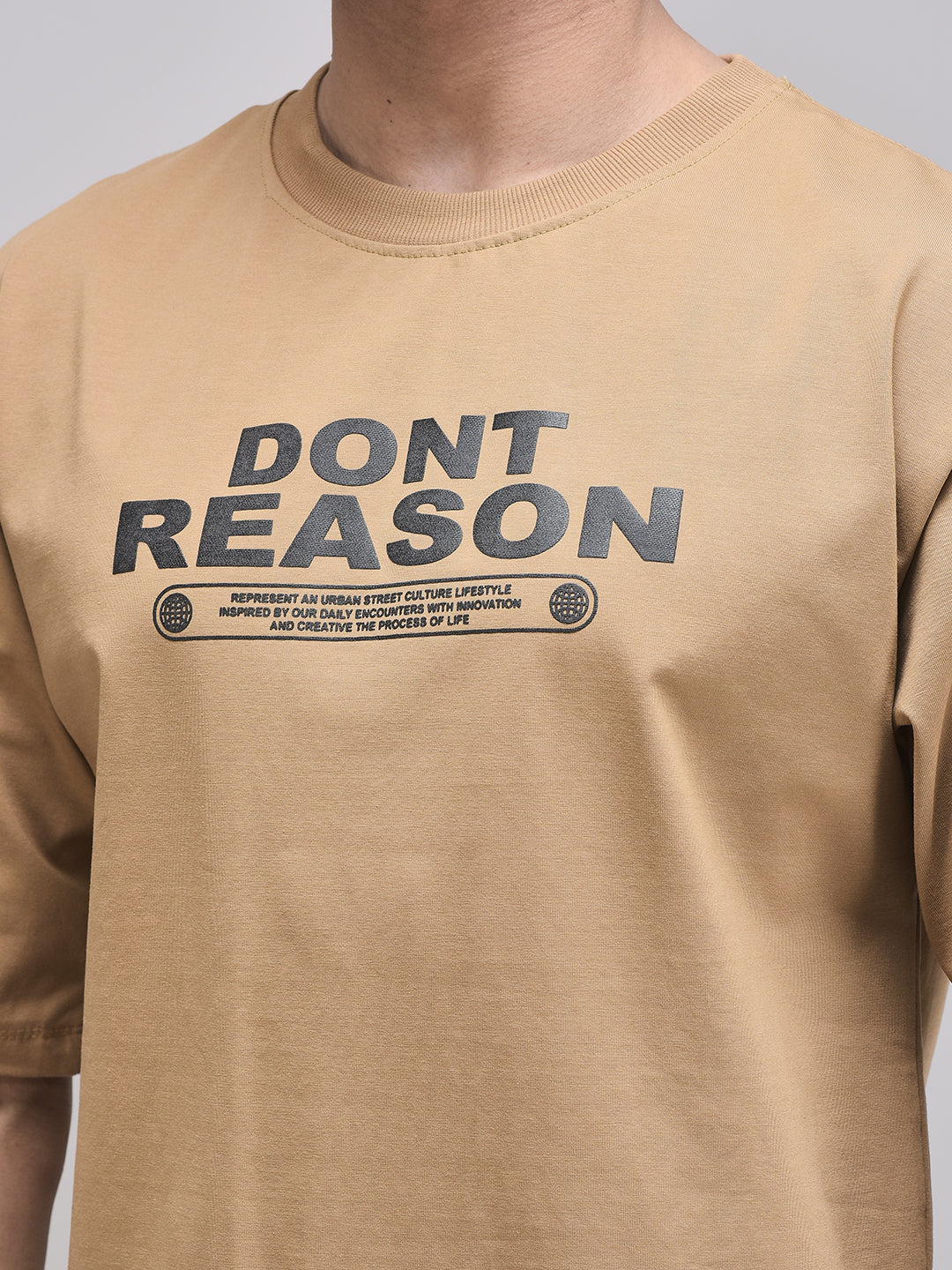 Don’t Reason puff print close-up on brown cotton fabric