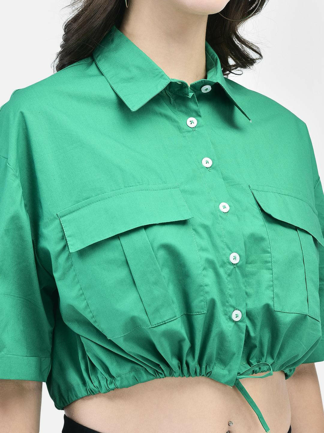 Close-up image of green women’s shirt showing front pockets, button detailing, and tie-up hem.