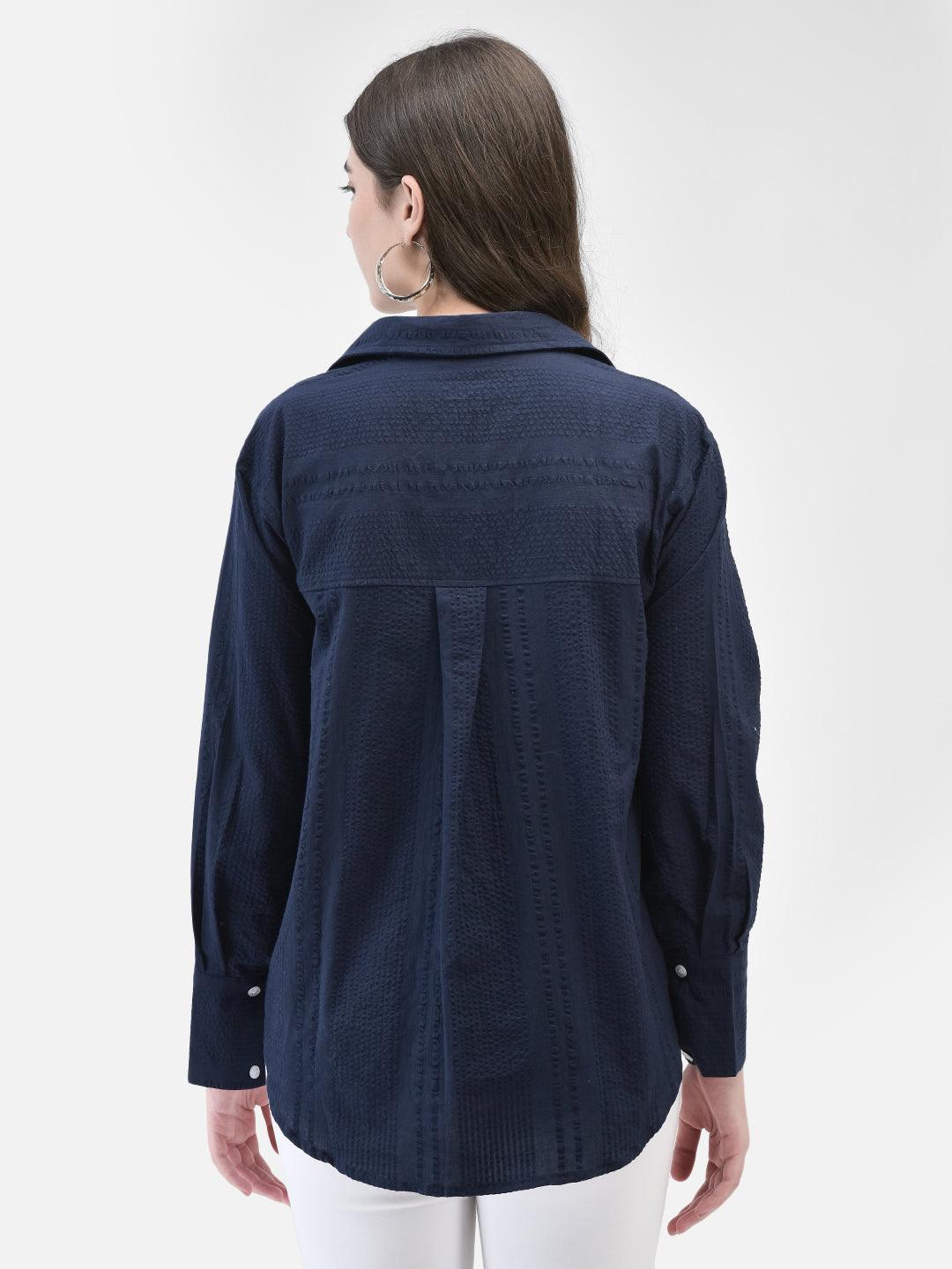 Back view of blue seersucker cotton shirt showing length and relaxed silhouette