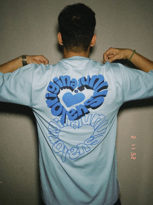 Person wearing a light blue t-shirt with a blue design on the back.