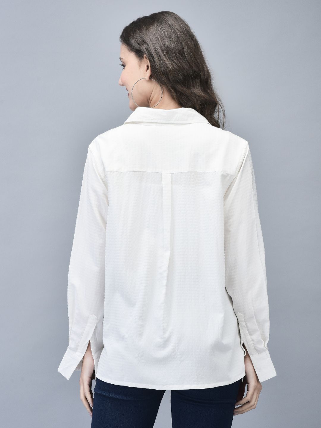Model displaying the back design of the textured white cotton shirt with a curved hem.