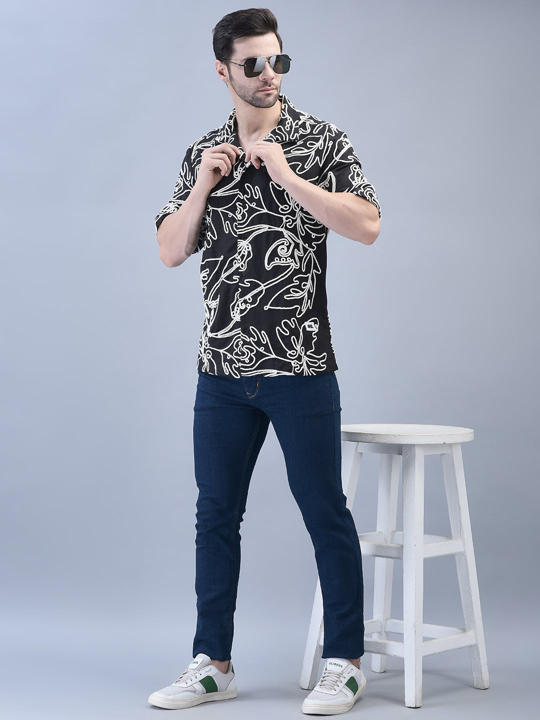 Full body view of man standing beside a white stool – floral embroidered black cotton shirt