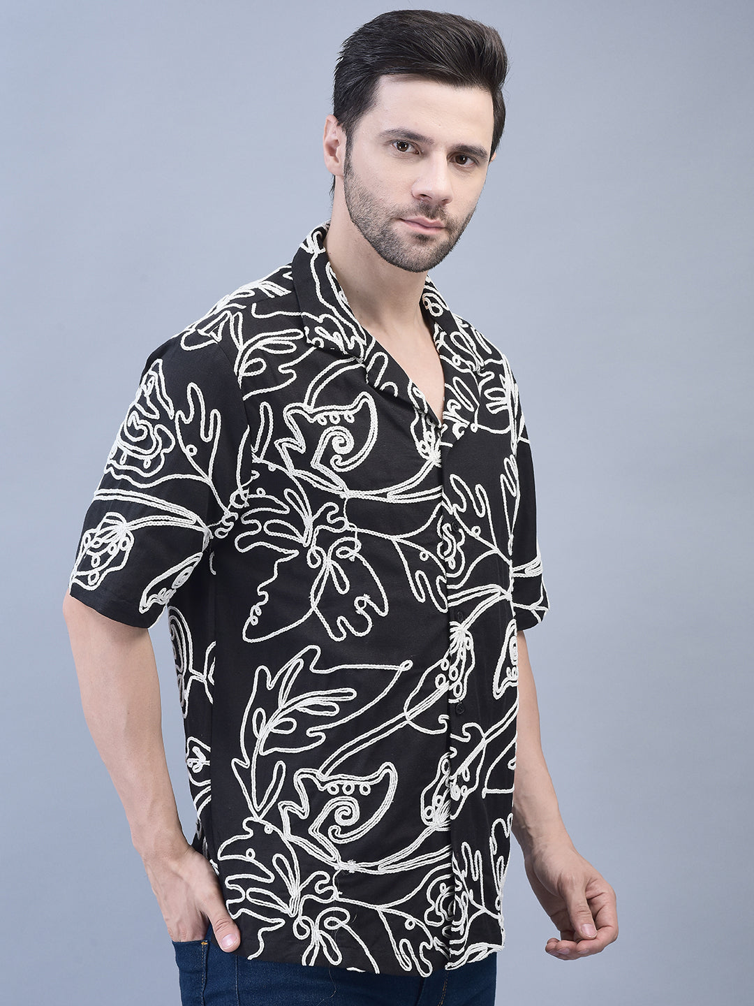 Side pose of man in oversized camp collar shirt – floral embroidery visible