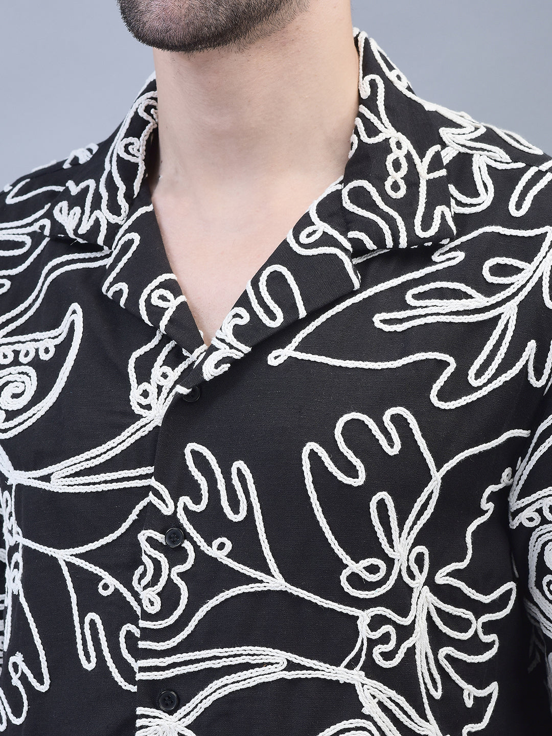 Close-up of embroidery and collar – white irises stitched on black cotton fabric