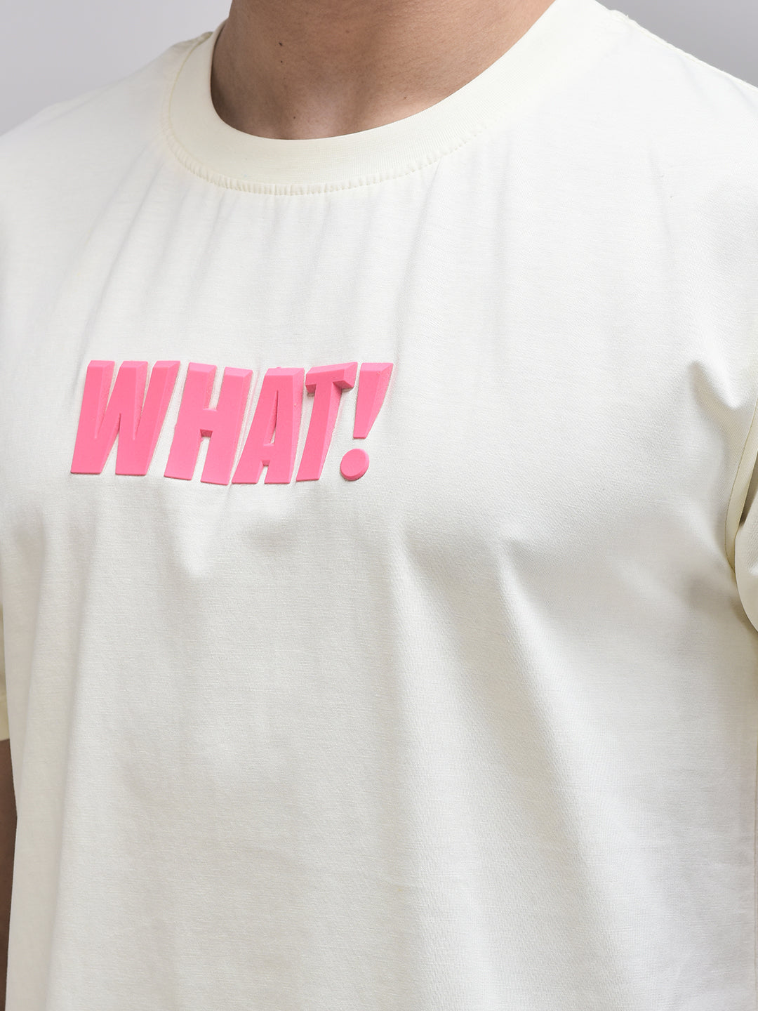 Zoom-in of pink WHAT! print on beige cotton t-shirt – oversized style