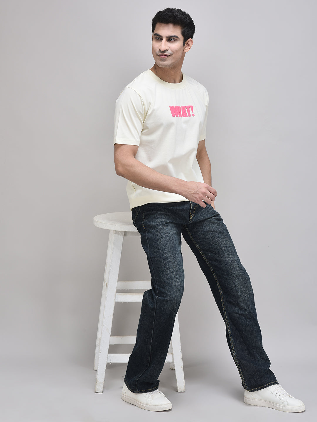Beige WHAT! t-shirt styled with black jeans – casual unisex streetwear
