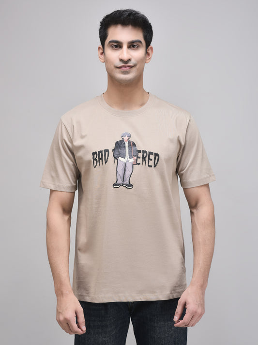 A male model wearing a beige oversized t-shirt with the text 'BAD TEMPERED' and a graphic print.