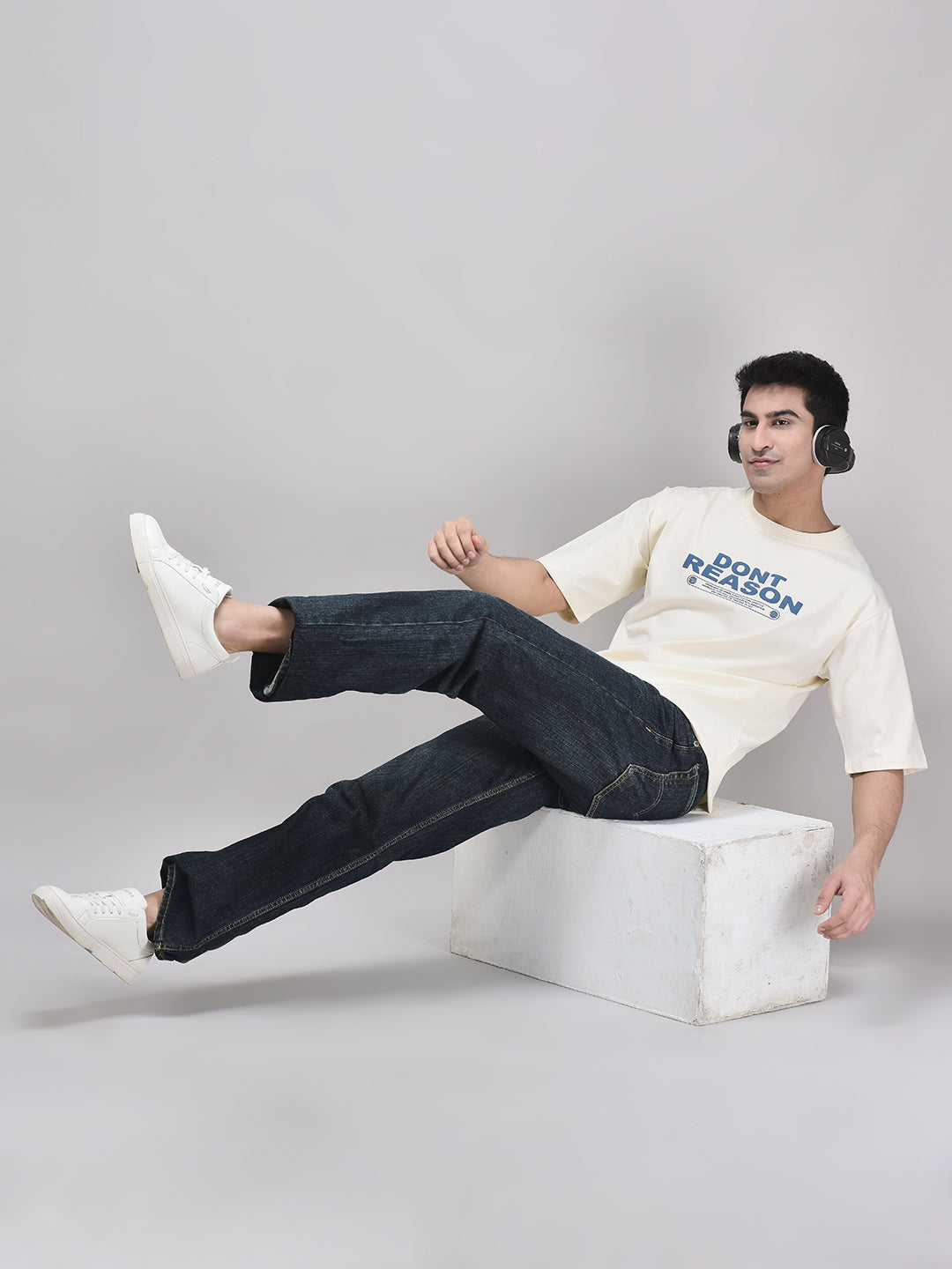 Oversized beige graphic tee with playful pose – casual streetwear look