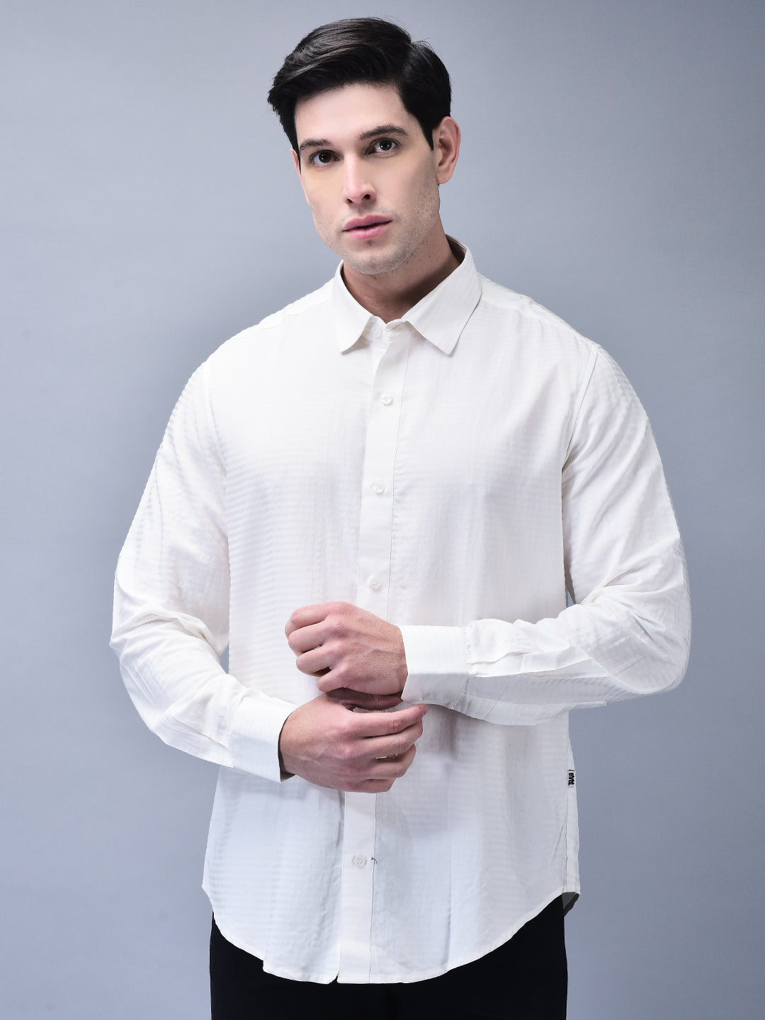Front view of man wearing slim fit white cotton shirt – hands adjusting cuff