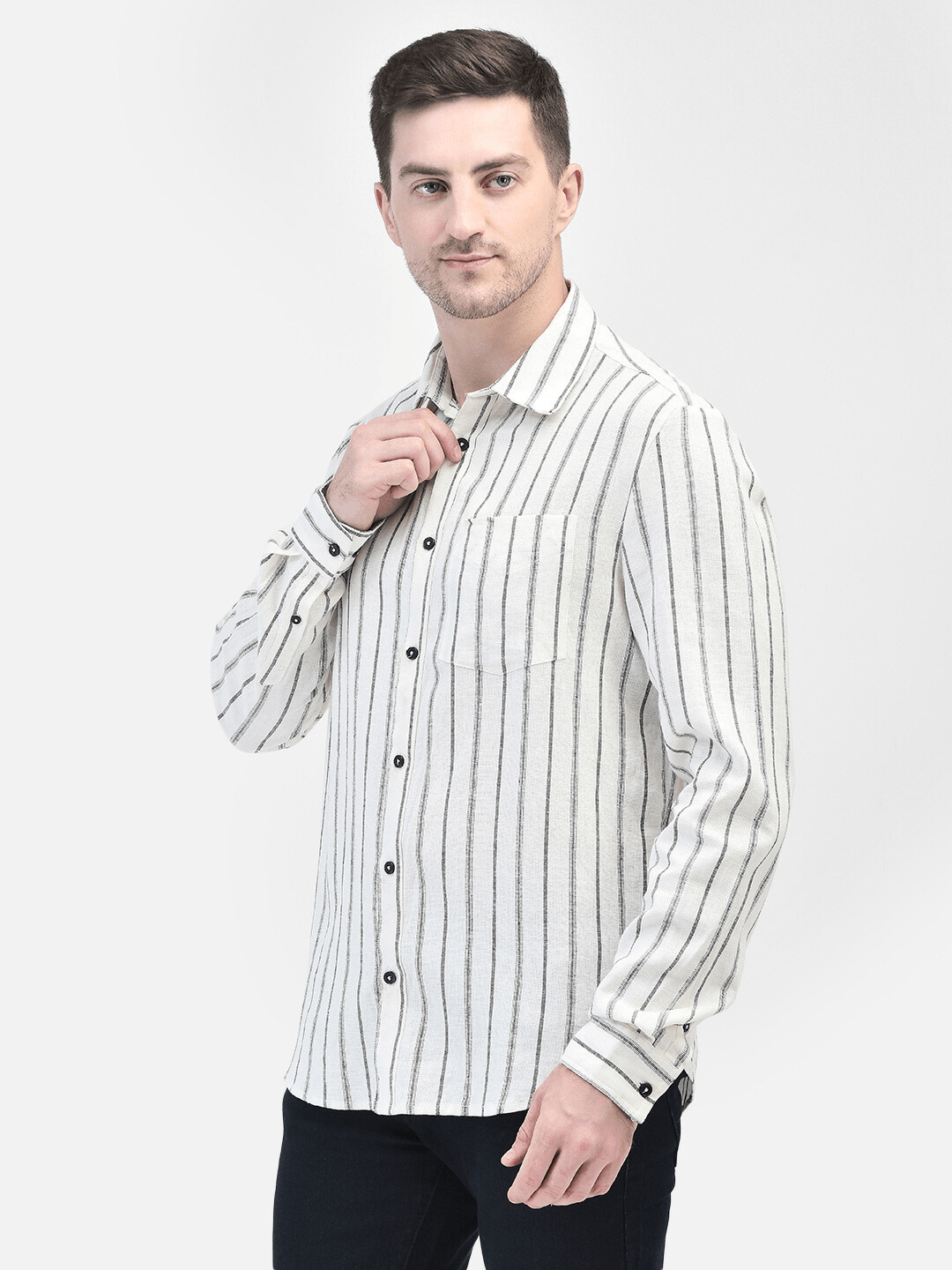 Side pose of man adjusting collar while wearing striped cotton linen shirt
