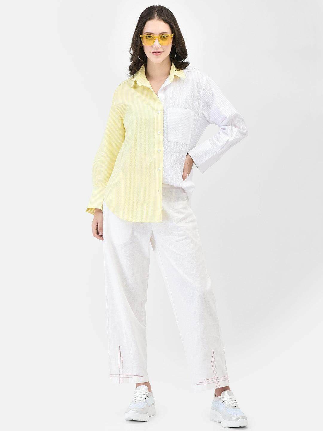Woman wearing yellow oversized cotton shirt with white pants and yellow sunglasses – summer street style