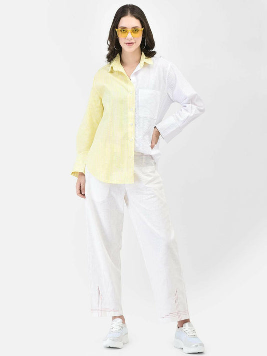 Woman wearing yellow oversized cotton shirt with white pants and yellow sunglasses – summer street style