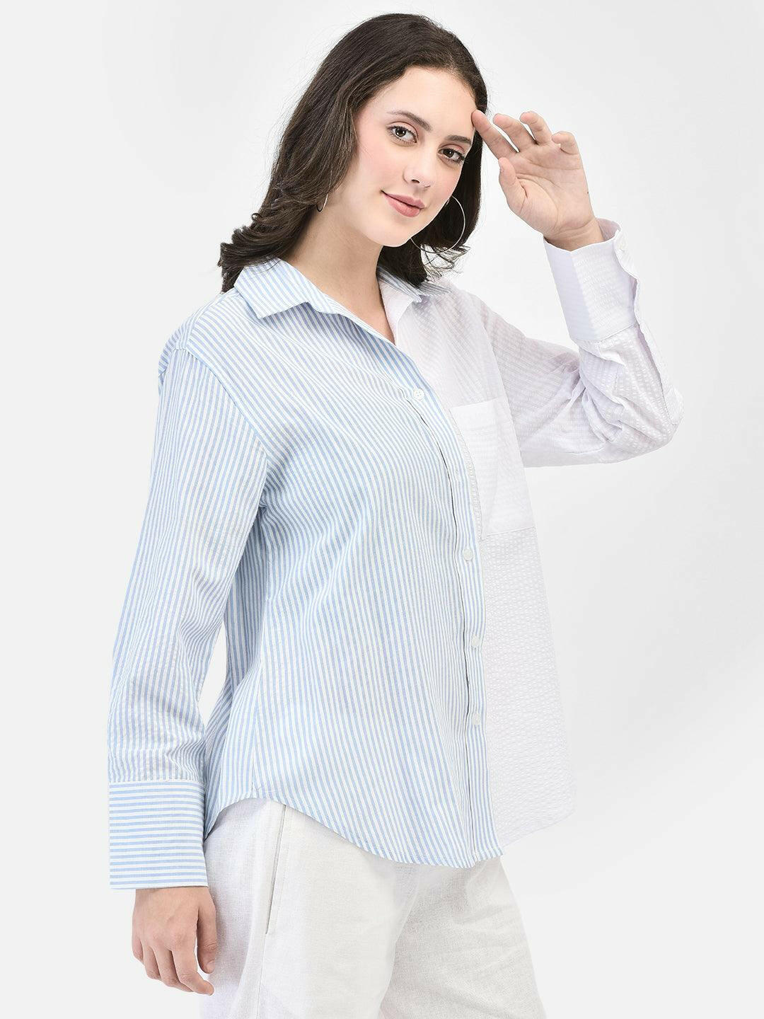 Side pose of woman in seersucker blue striped shirt – summer styling look