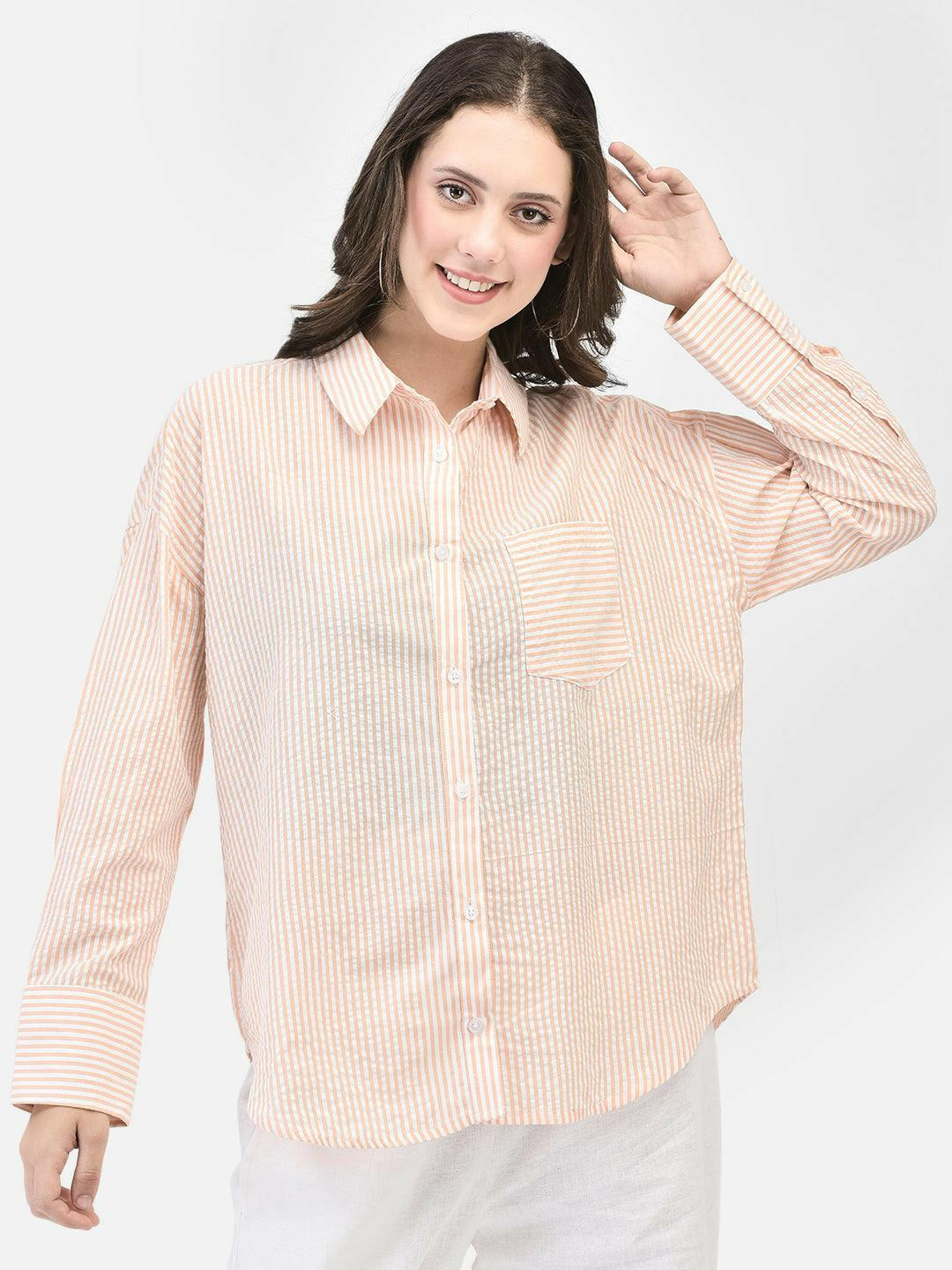 Front view of woman in apricot seersucker shirt – relaxed fit and buttoned up