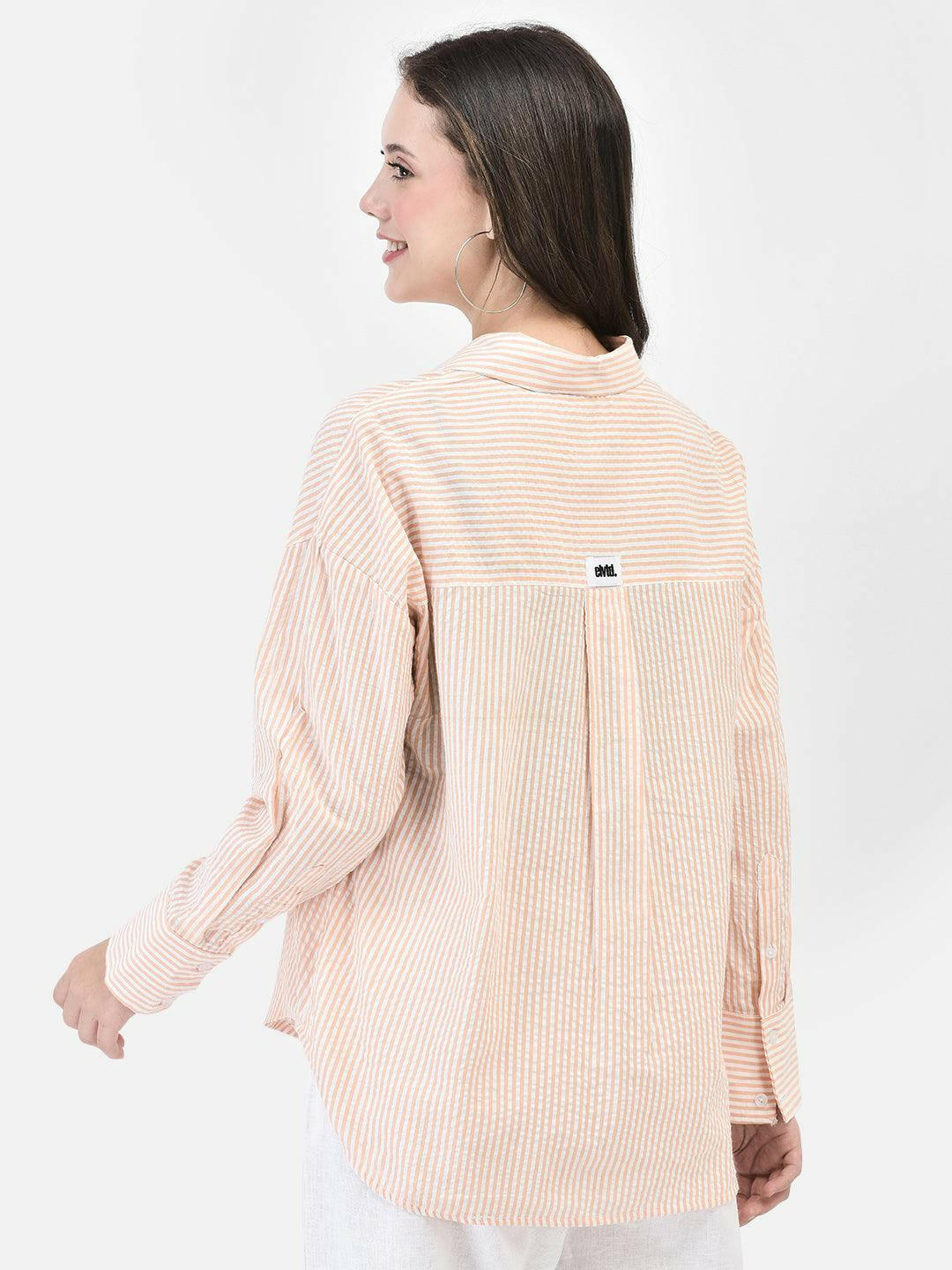 Three-quarter back view of peach cotton shirt – relaxed silhouette with drop shoulders
