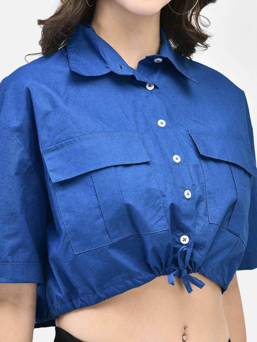 Close-up view of chest pockets and collar on blue cropped shirt