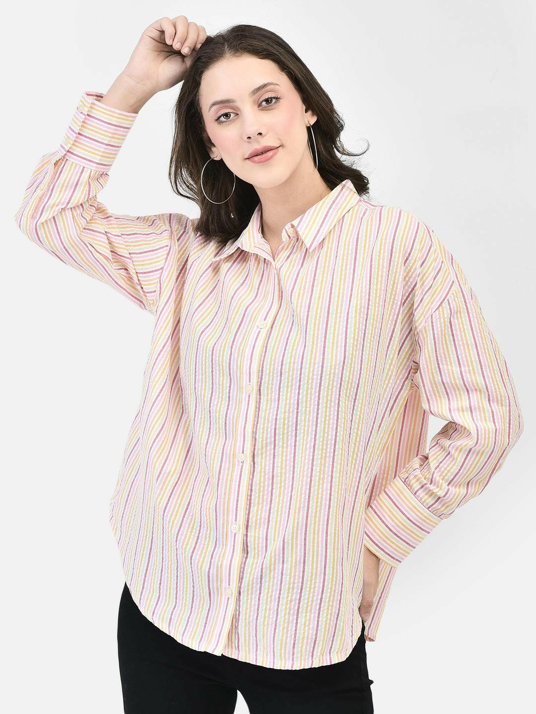 Front view of woman in pink seersucker shirt – posing with one hand in hair