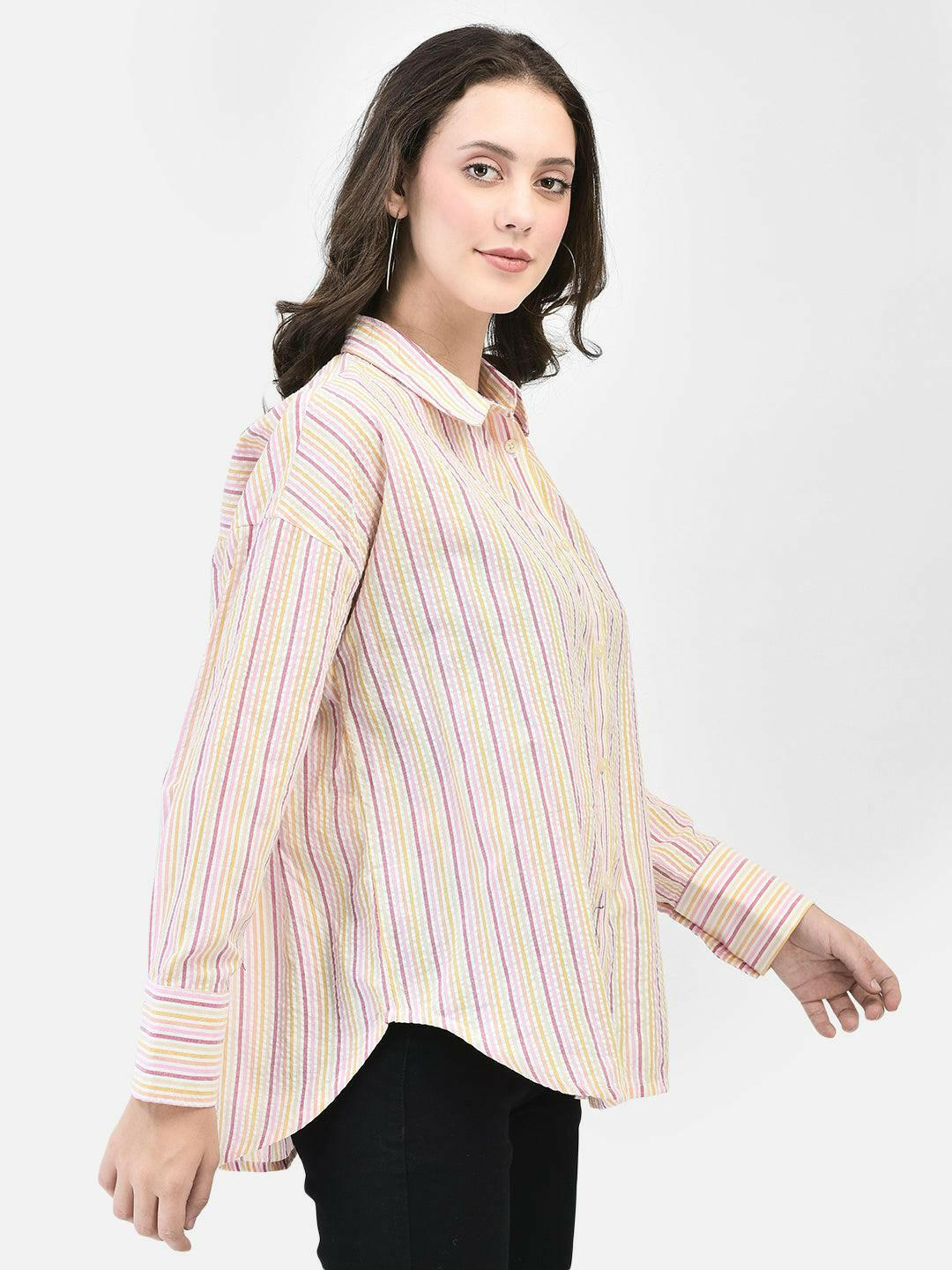 Three-quarter view of woman in cotton striped shirt – hands down, smiling