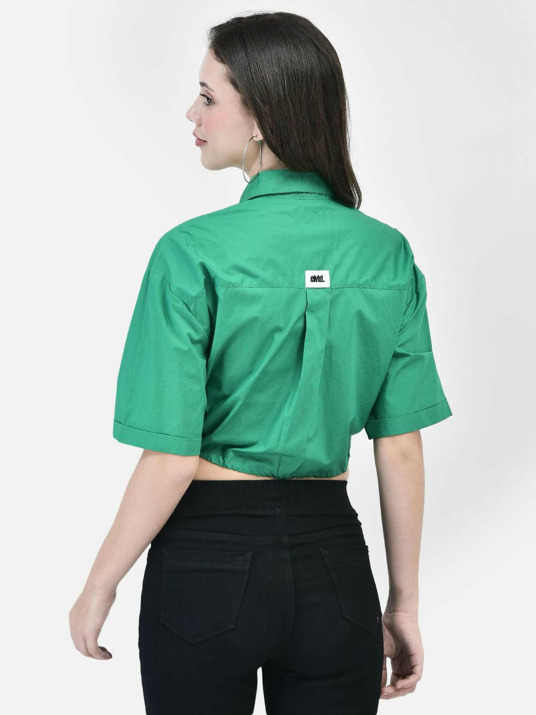 Back view of green cropped cotton shirt for women, showcasing yoke and box pleat design.