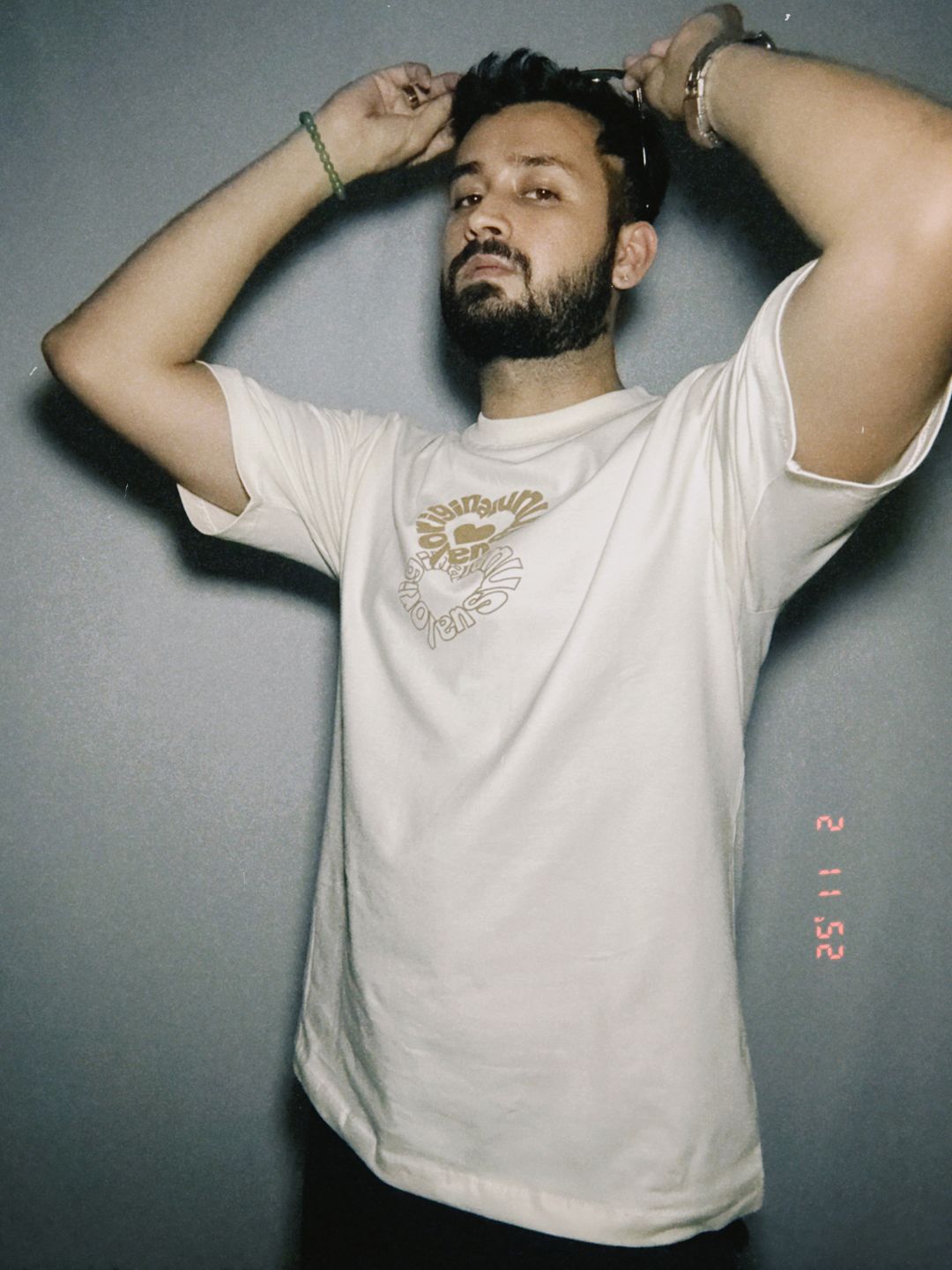 Person wearing a light-colored t-shirt against a plain background