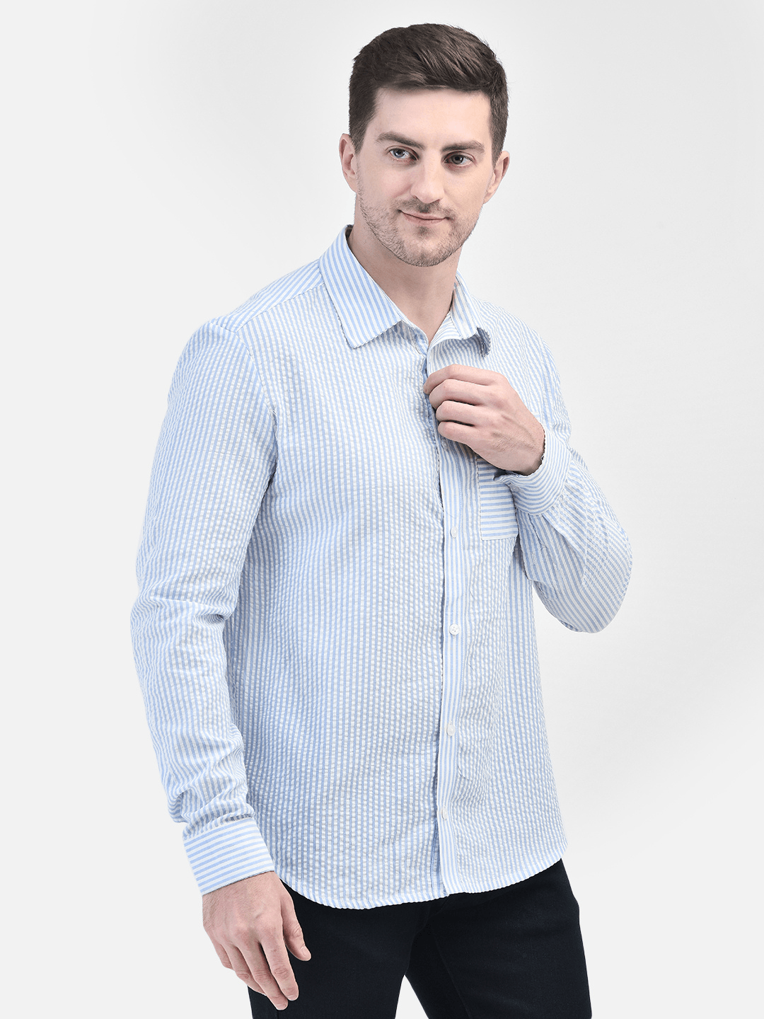 Front view of man wearing light blue cotton shirt – standing with hand by side