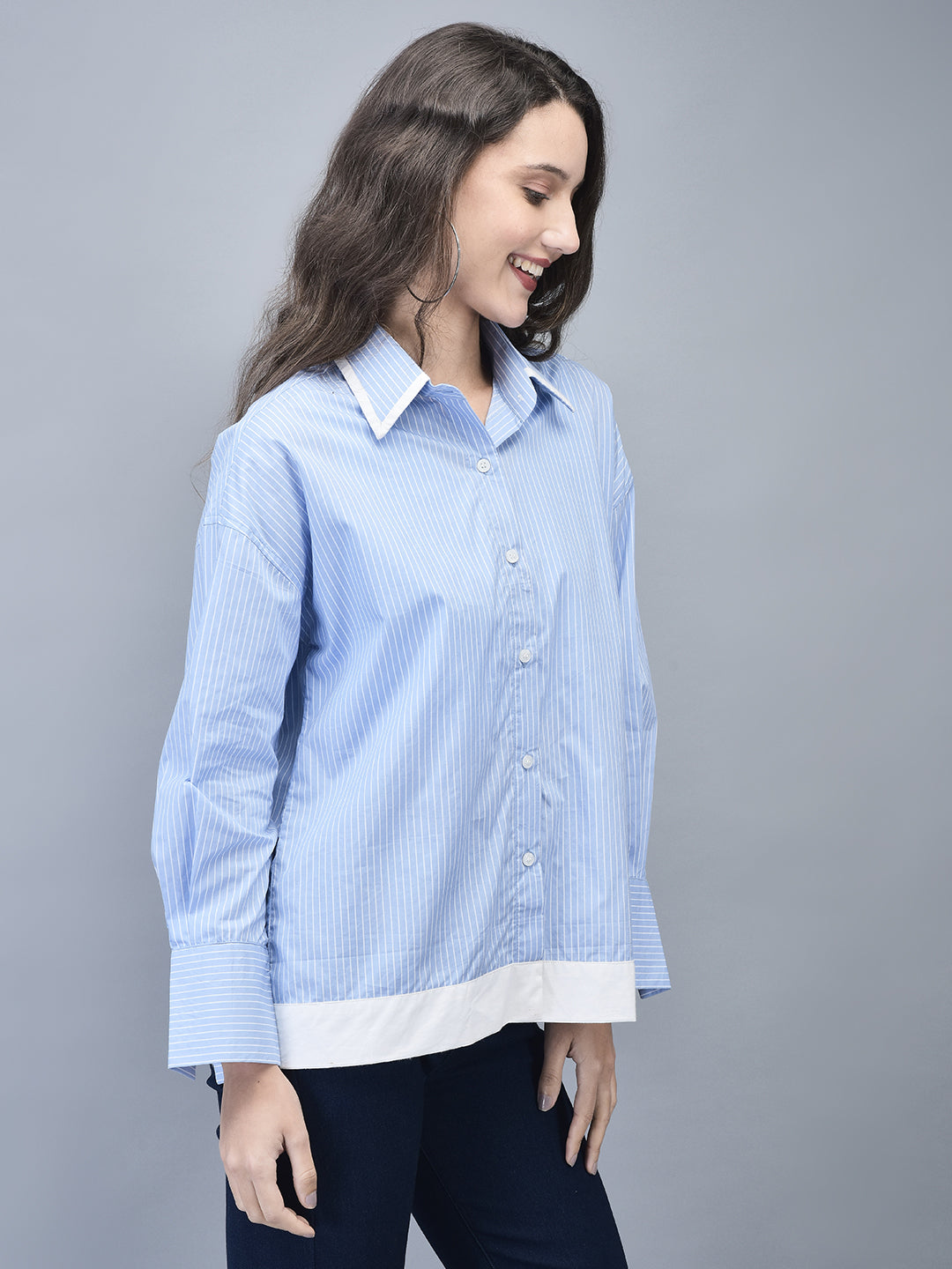 Side profile of woman in blue pinstripe shirt and white heels
