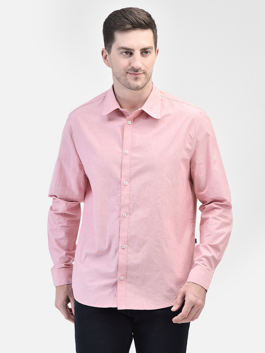 Male model facing front in pastel pink cotton shirt with hands down
