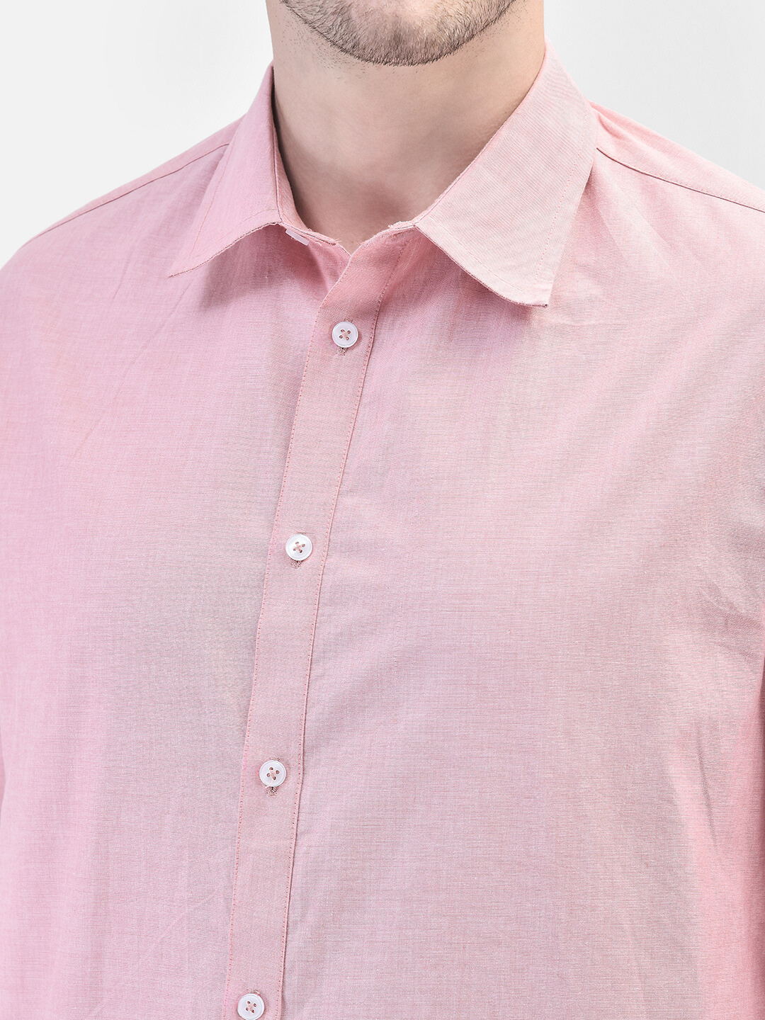 Close-up shot of chambray fabric and shirt collar detailing in pastel pink
