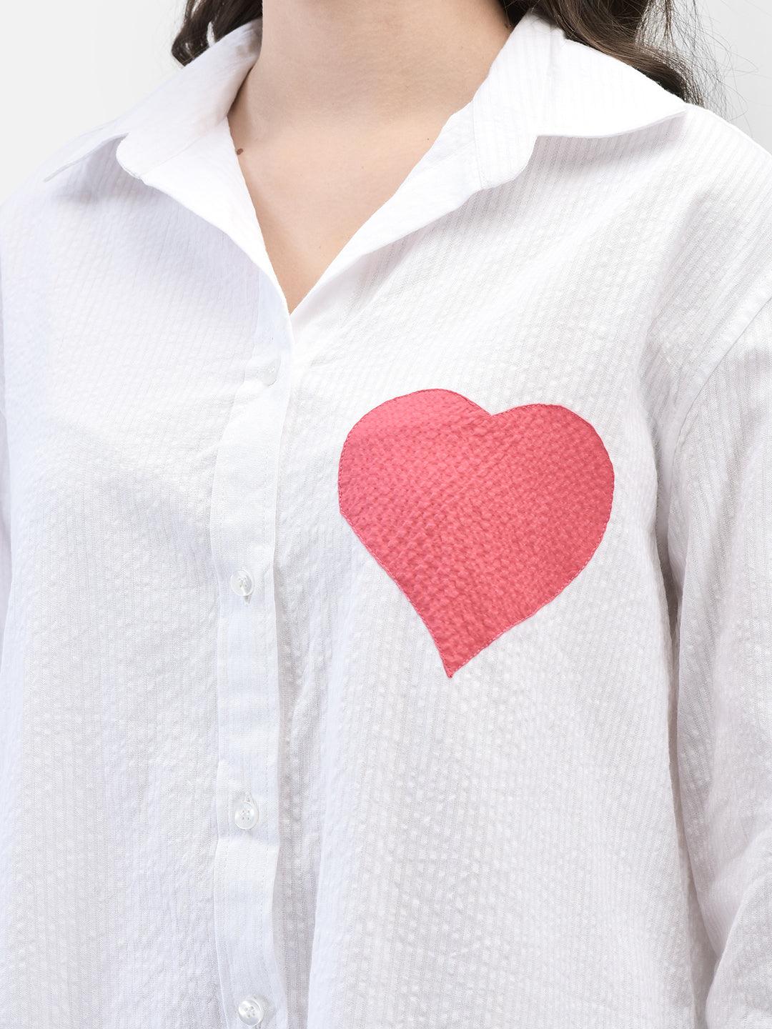 Close-up of red heart patch and collar details on white seersucker cotton shirt