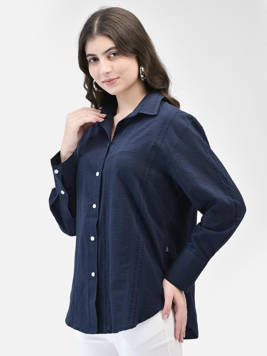 Side profile of model in navy blue seersucker cotton shirt showing relaxed fit
