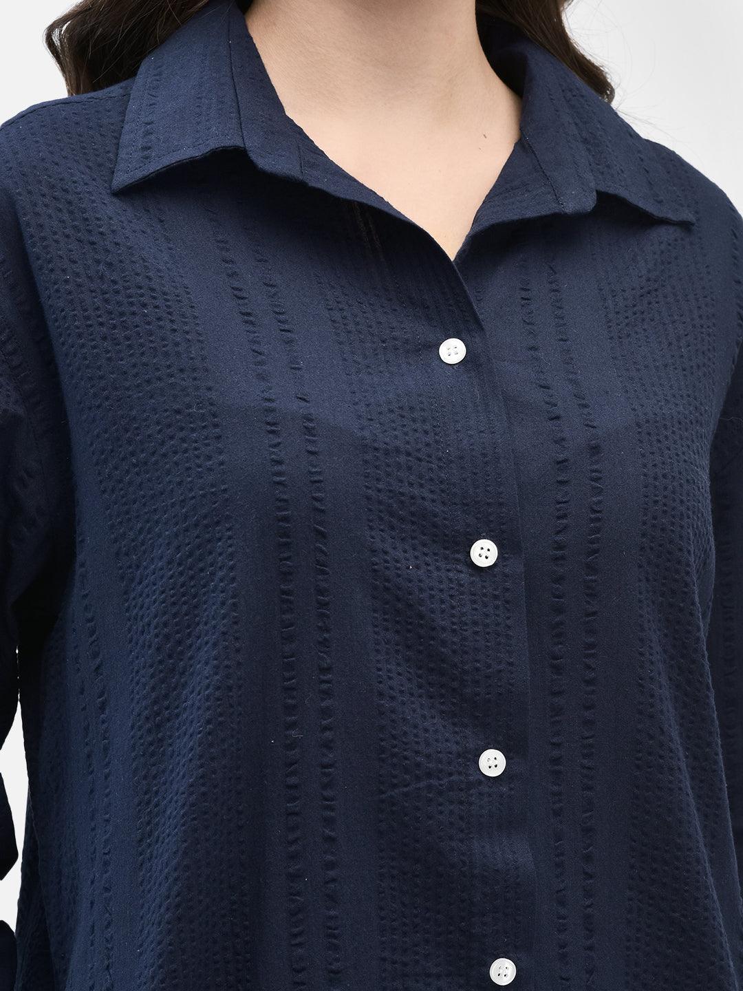 Close-up of textured seersucker cotton fabric in sapphire blue shirt with buttons