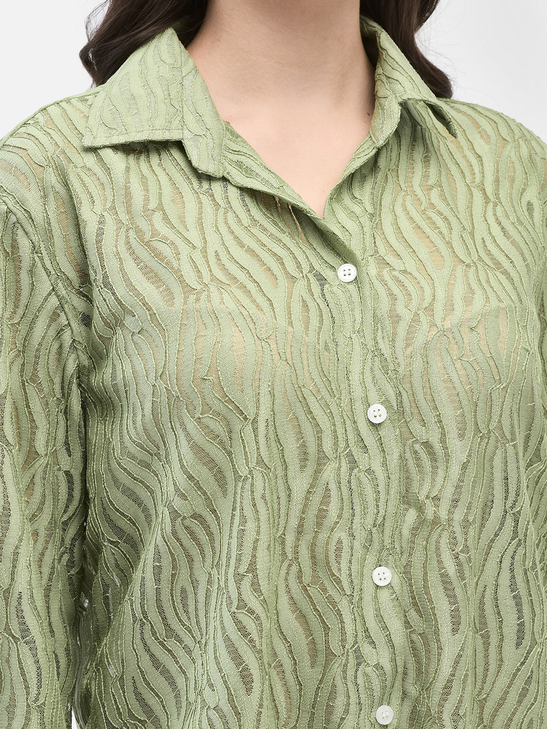 Close-up of the shirt texture and front button detail of pistachio crochet shirt