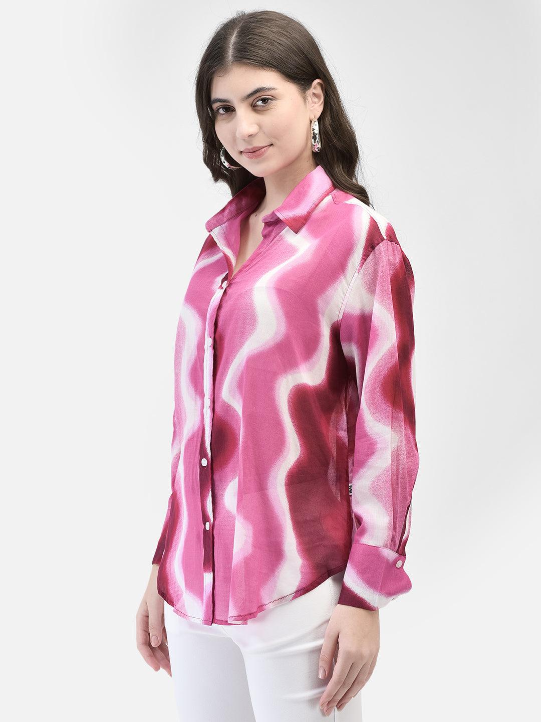 Side pose of woman wearing abstract wavy print shirt