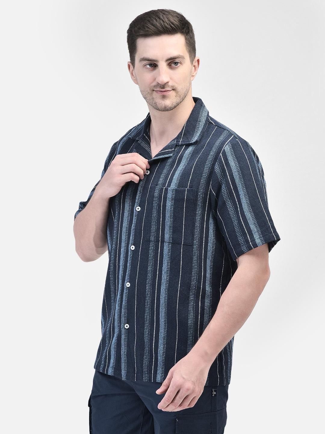 Man adjusting collar of navy cotton shirt – casual striped shirt for men