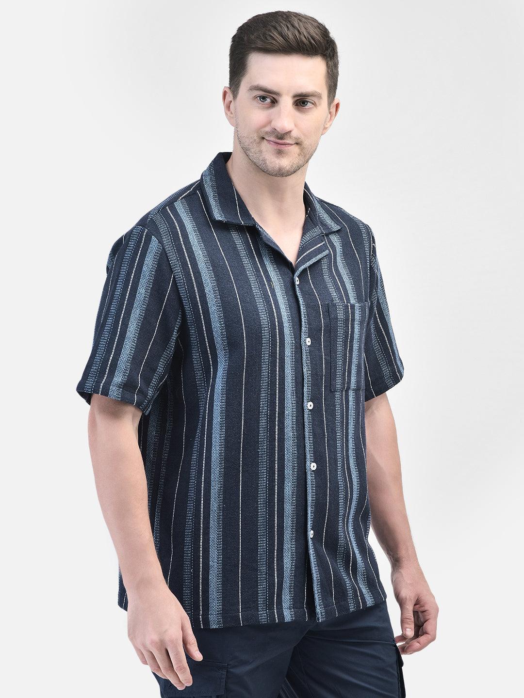 Three-quarter front view of man in navy blue vertical striped shirt – short sleeves