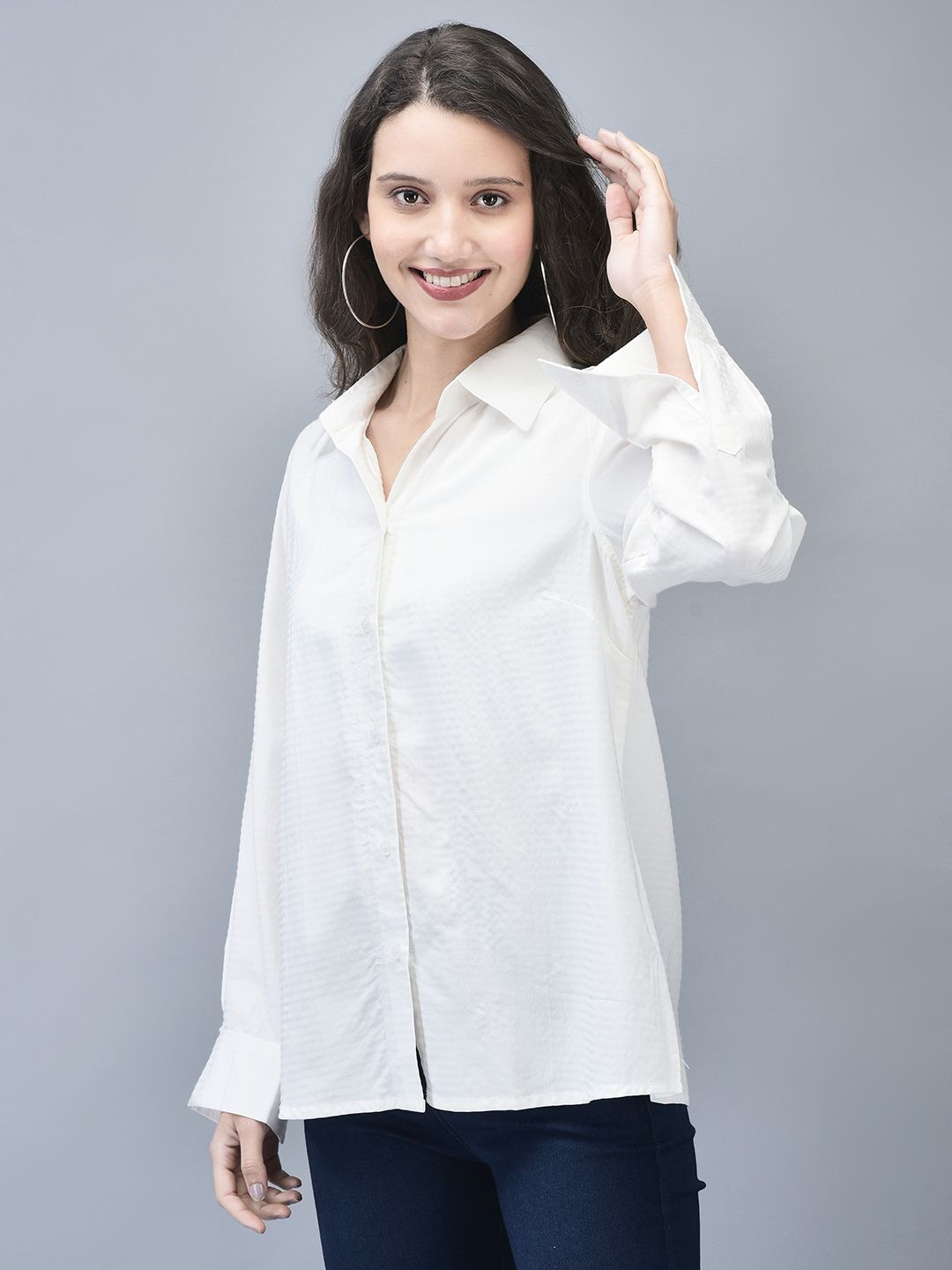 Woman smiling in a relaxed pose, highlighting the breathable fit of the white striped shirt.