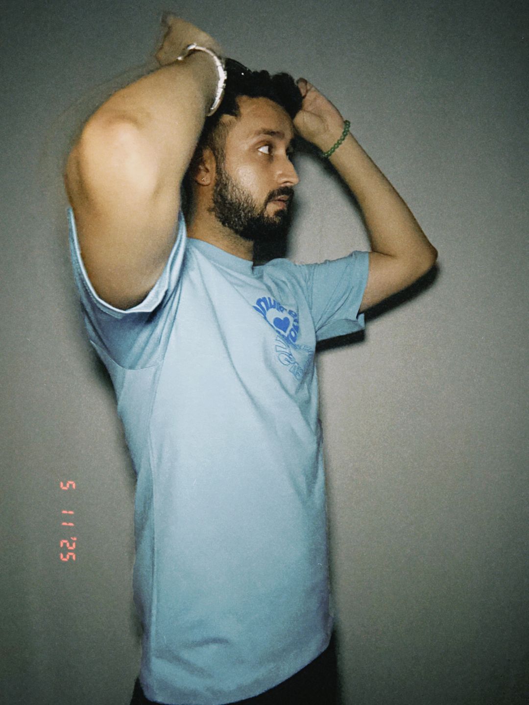 Person wearing a light blue t-shirt against a plain background