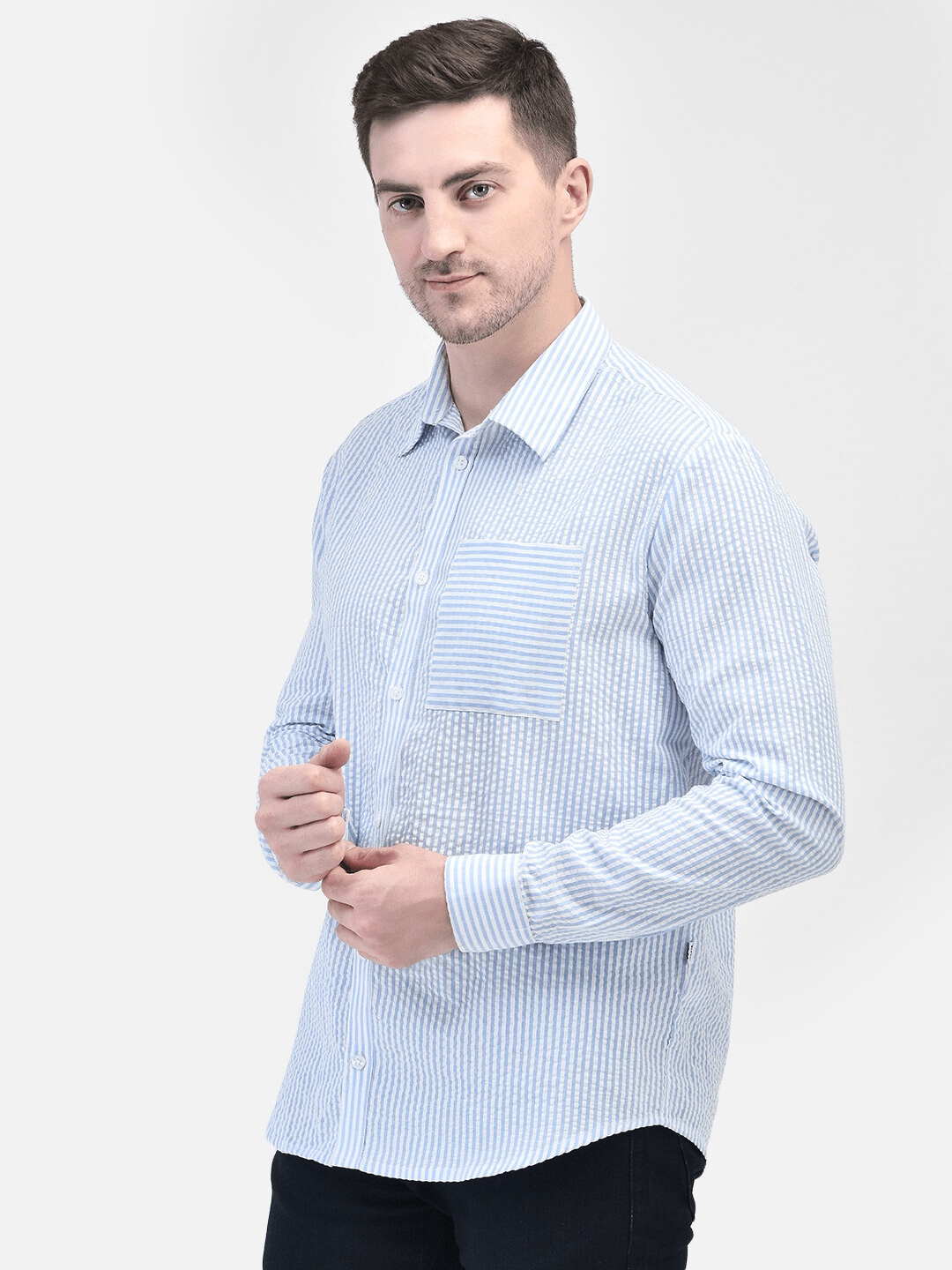 Man adjusting shirt cuff – front view of men’s blue summer shirt