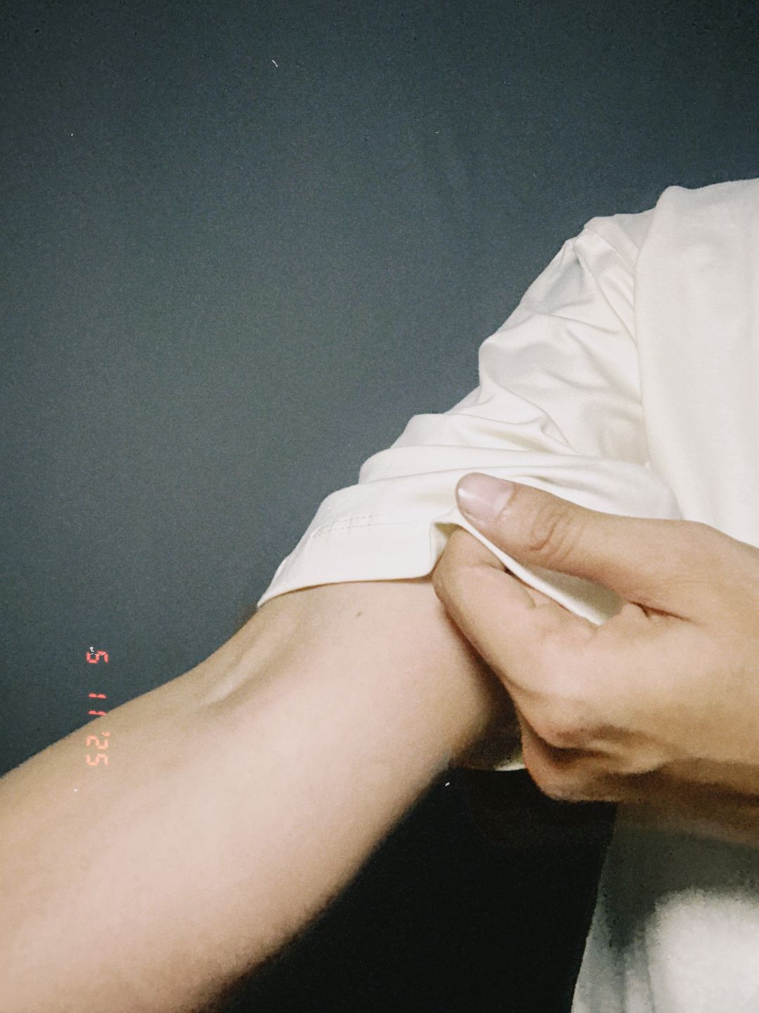 Person applying a bandage to a arm against a dark background