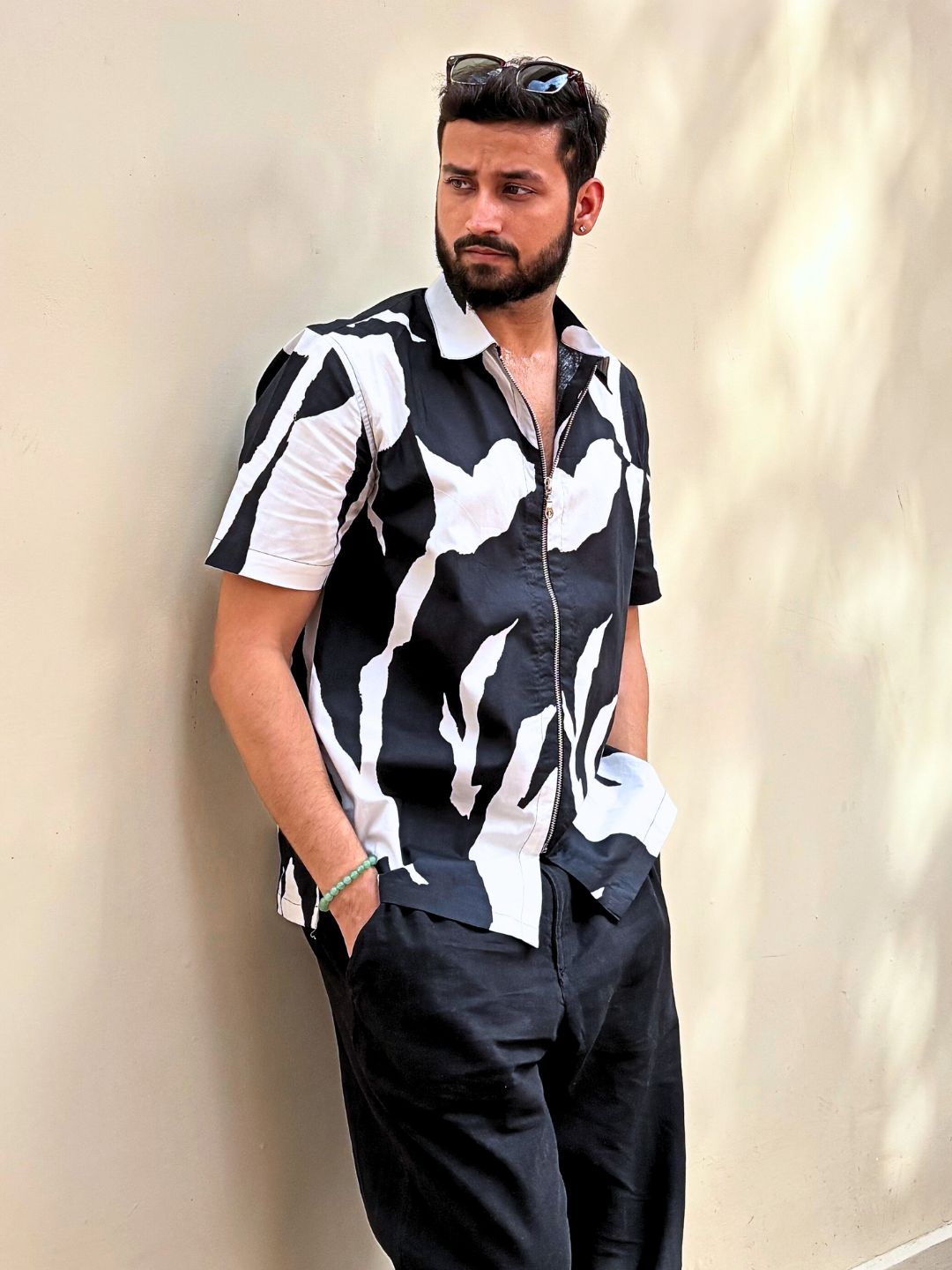 Man posing against a wall wearing graphic zippered cotton shirt – casual vibe