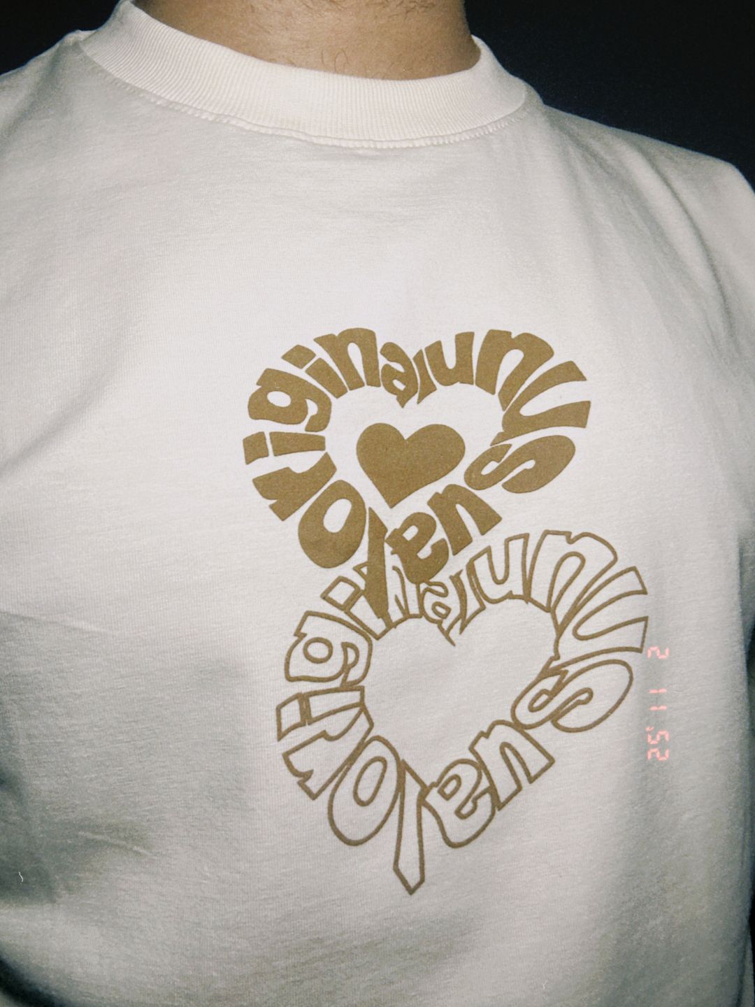 White t-shirt with brown text and graphics on the back.