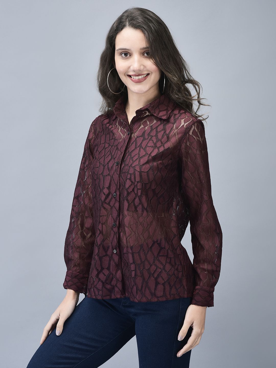 Woman in wine textured shirt standing with one hand on her hip, front angled view