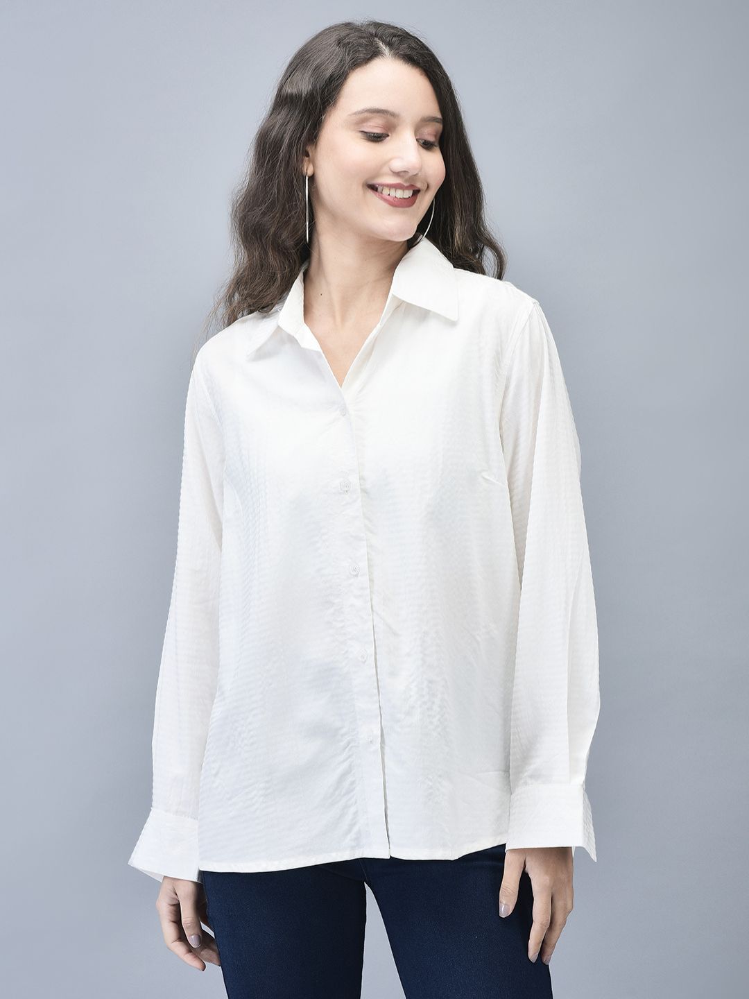 Model standing straight in a full-sleeve white shirt with subtle textured stripes and dark trousers.