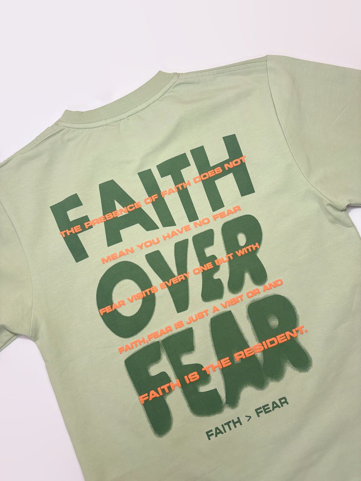 Light green t-shirt with motivational text on a white background