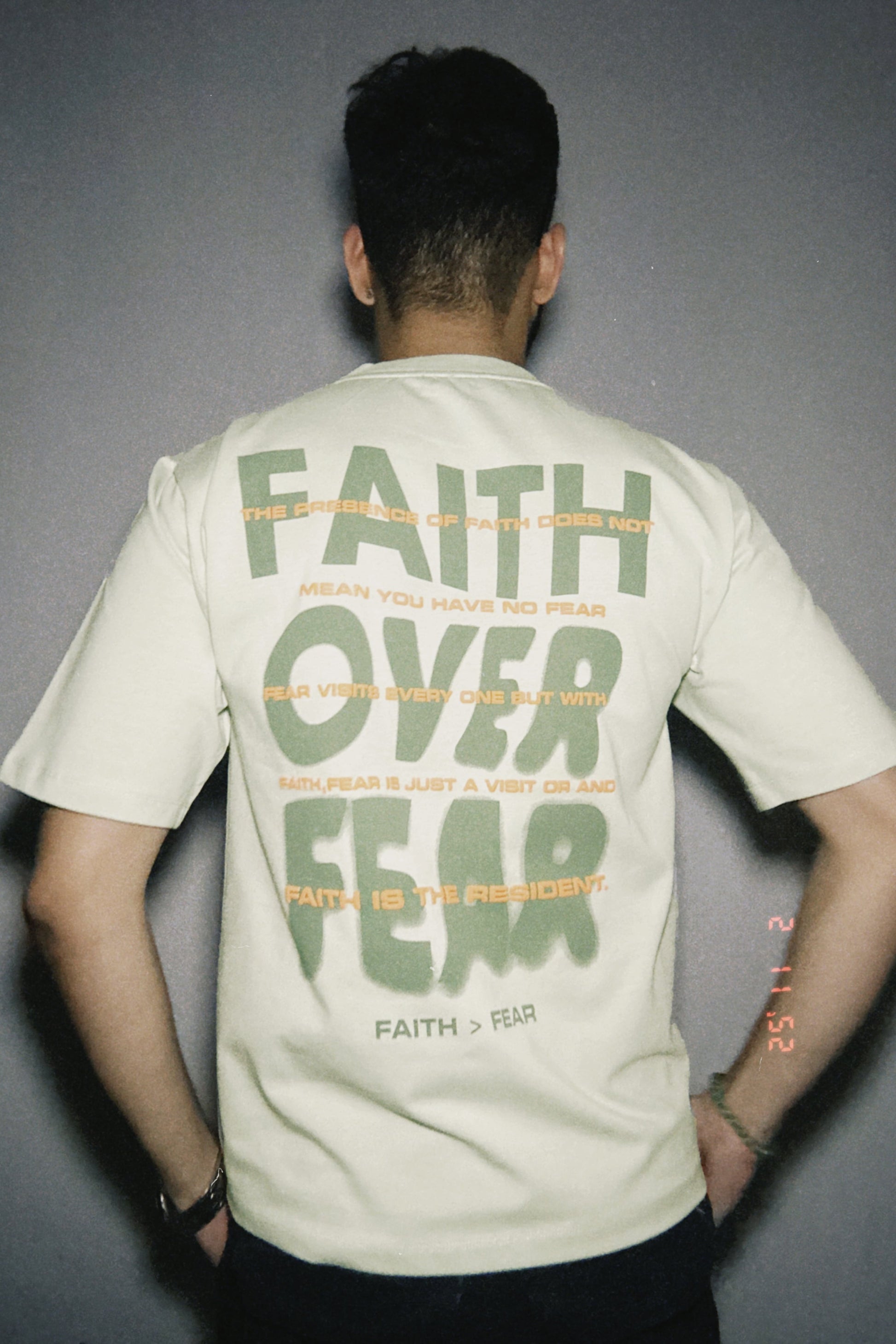 Person wearing a t-shirt with 'Faith Over Fear' text on the back.