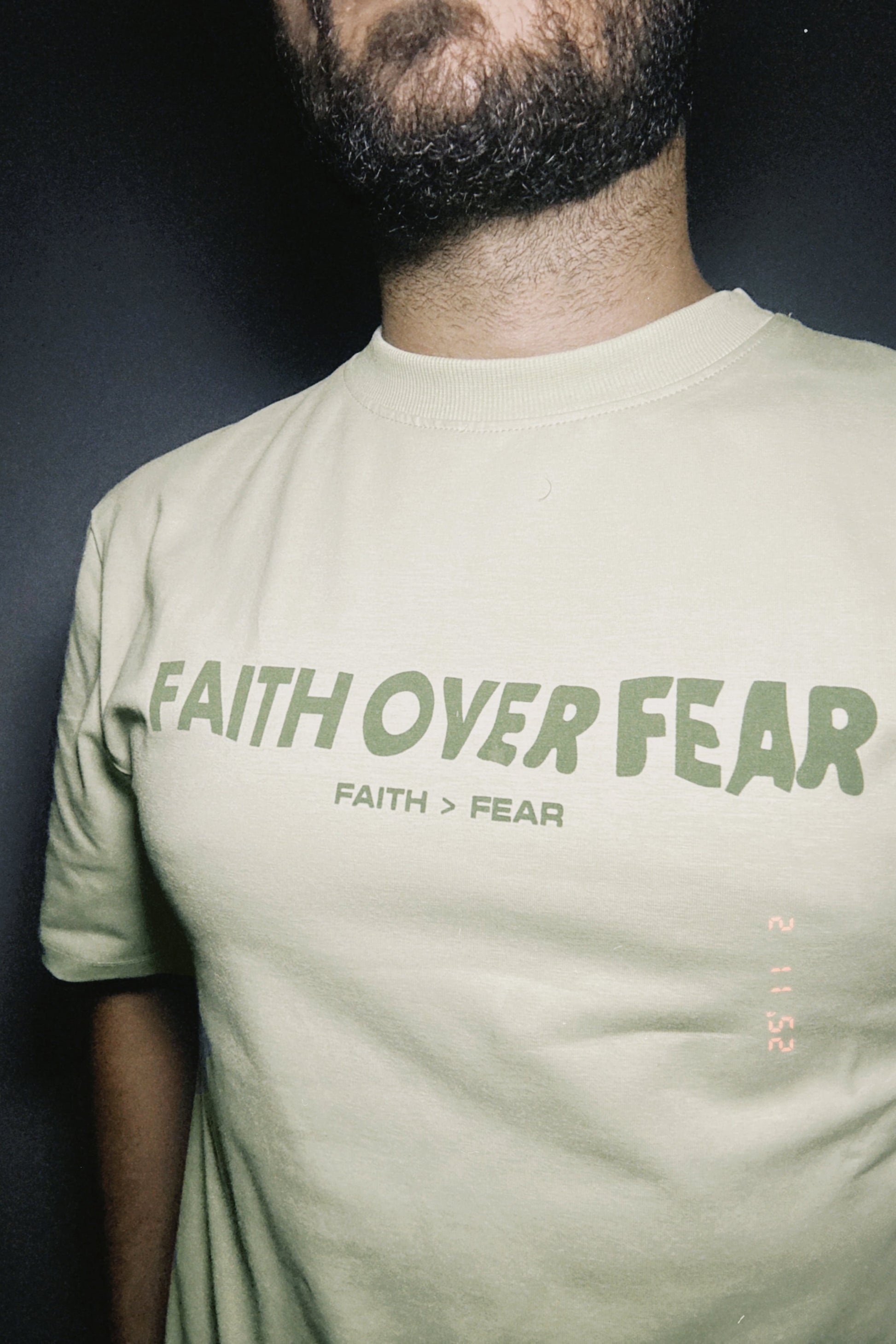 Person wearing a t-shirt with 'Faith Over Fear' text.