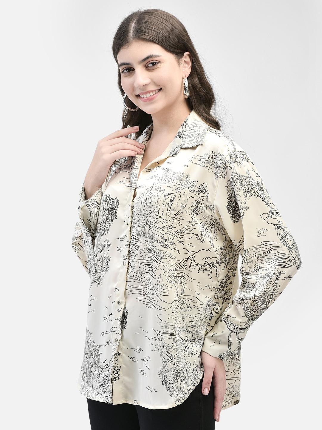 Model wearing a beige satin printed shirt with black pants, smiling and posing front-facing